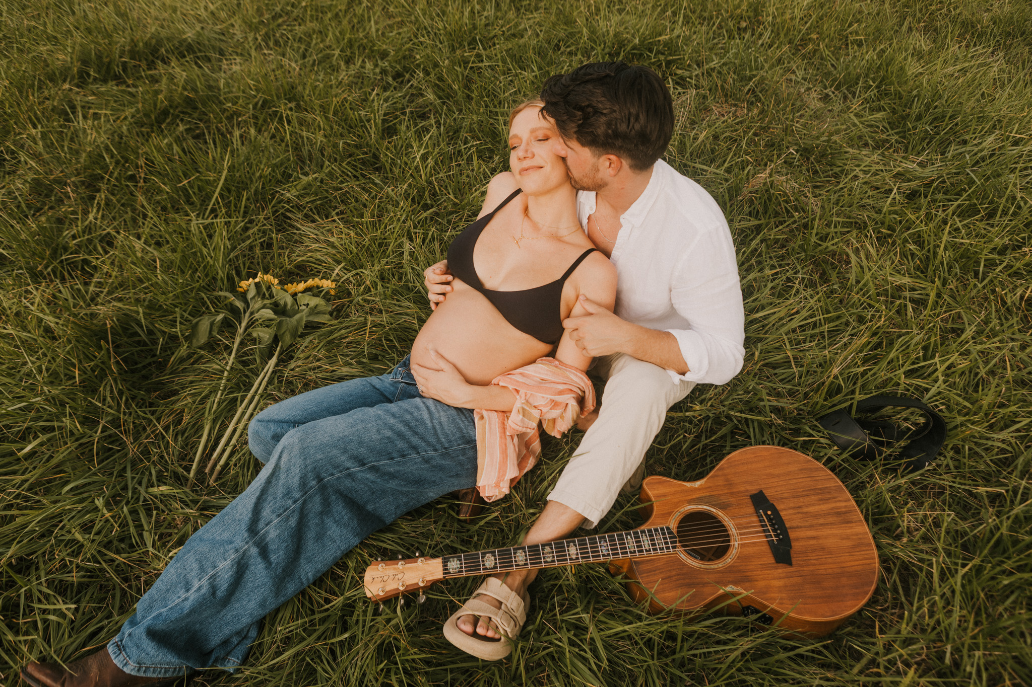 Couple kissing in sunset field their beautiful maternity photoshoot southern highlands nsw