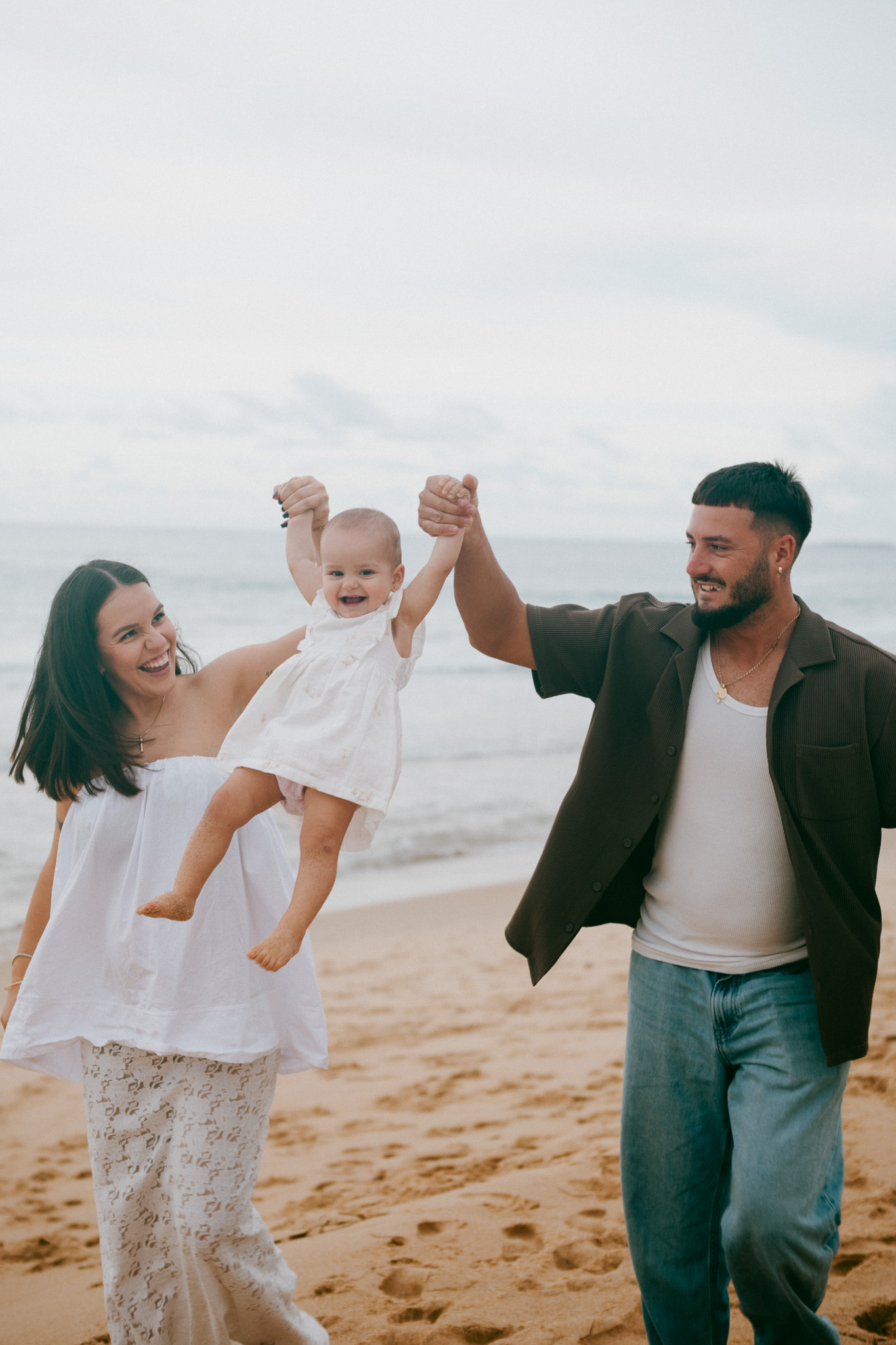 Wollongong beach maternity and family photo of parents holding 14 month old daughter at sunset